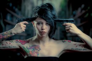 銃とタトゥーの女性